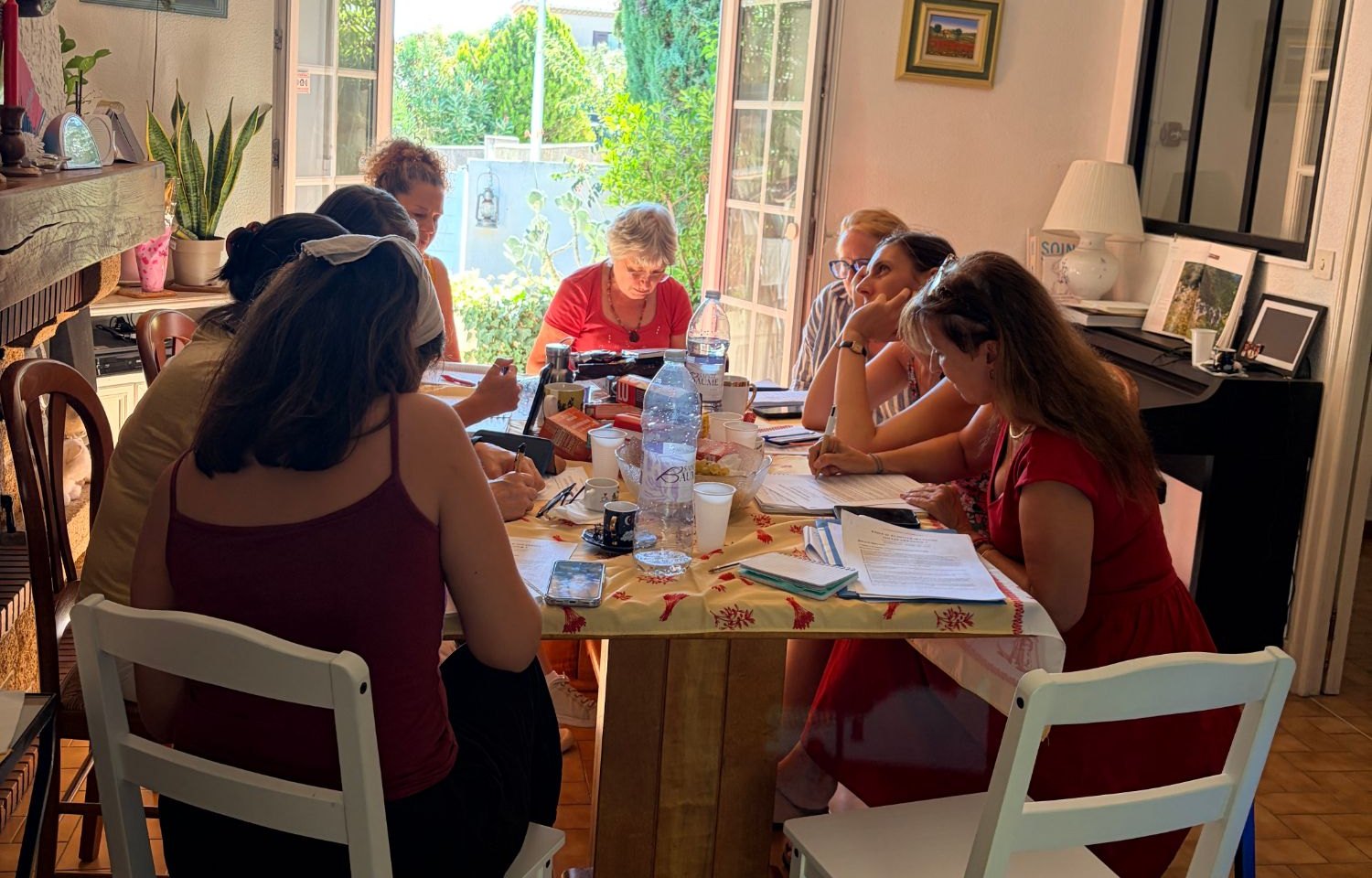 Les participantes du stage « Faut-il écouter ses peurs ou les dépasser ? » réunies autour d’une table, à Marseille, portes ouvertes sur le jardin.